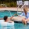 residents clink drink glasses at the pool